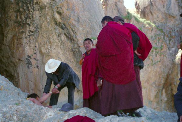 4327.jpg - monks doing the kora. This monk crawls through a hole, as a religious act.