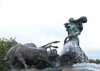 a statue of the Norse goddess Gefion as she spurs on her oxen. The statue sits atop a fountain near the harbor in Copenhagen
